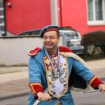 Schützenkönig in blauer Uniform mit Orden, Königskette und Säbel