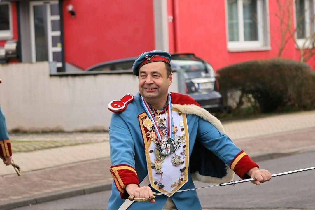 Schützenkönig in blauer Uniform mit Orden, Königskette und Säbel