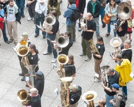 Blaskapelle mit zahlreichen Blechbläsern auf einem belebten Festplatz