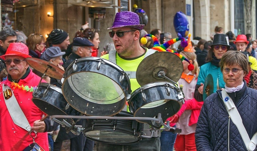 Festzug mit Trommler und großem Schlagzeug zwischen kostümierten Menschen